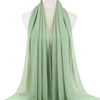 Ein hellsalbegrüner Chiffon-Hijabschal über einem Mannequin-Hals drapiert.