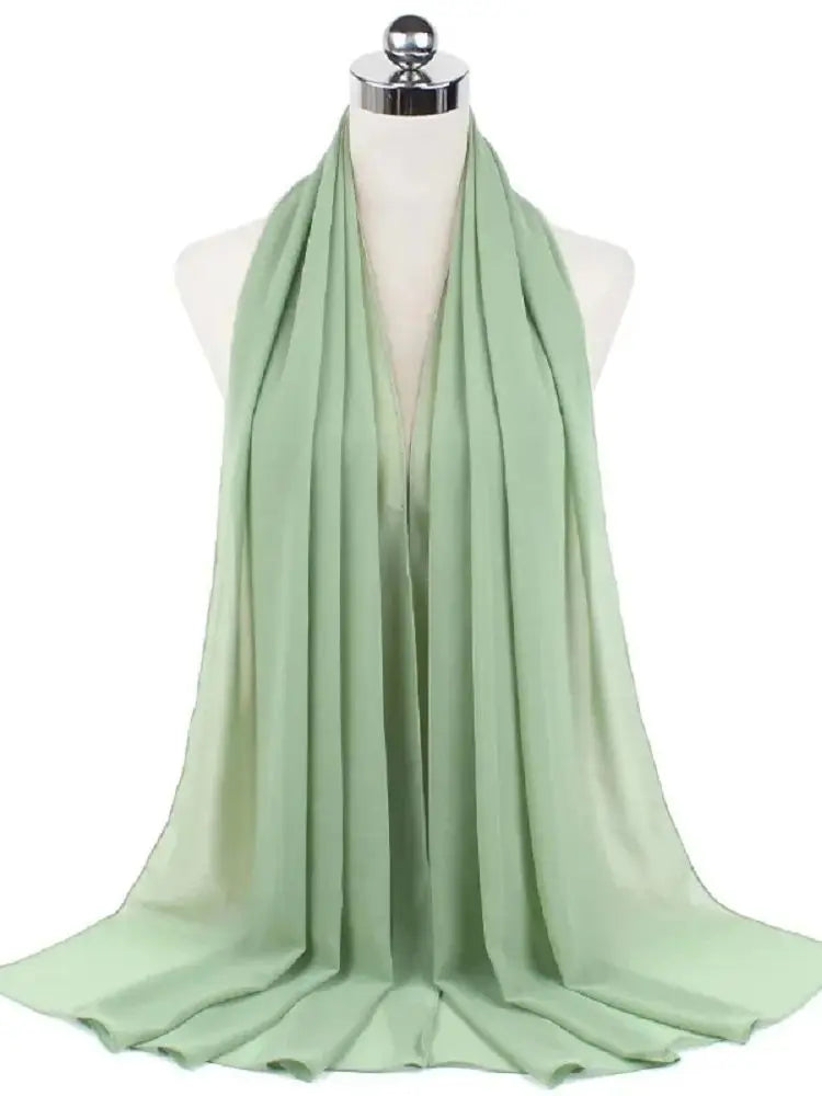 Ein hellsalbegrüner Chiffon-Hijabschal über einem Mannequin-Hals drapiert.