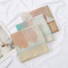 Beige und rosa floral gemusterter Voile-Schal in Hijabform auf weißem Untergrund.