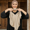 Une femme modélise un foulard instant beige en triangle drapé sur sa poitrine sur un fond en bois.