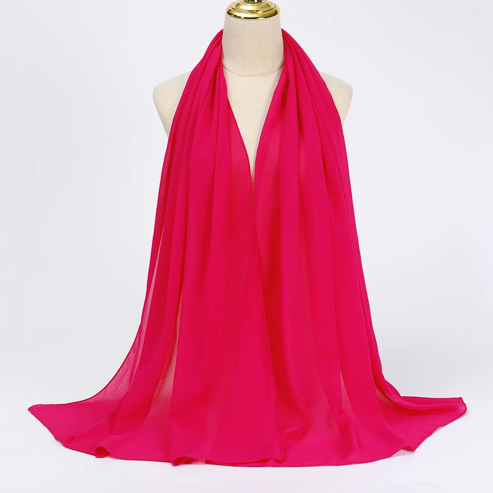 Leuchtend magenafarbener Chiffon-Hijab-Schal um den Hals einer Mannequin drapiert.