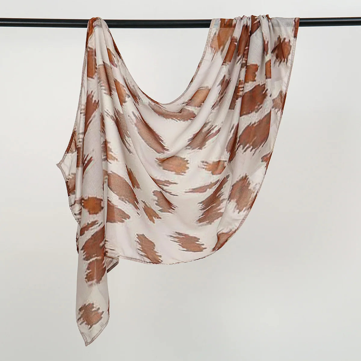 Fließender beige-brauner Aquarell-Ombré-bedruckter Rayon-Modal-Hijab-Schal aufgehängt.