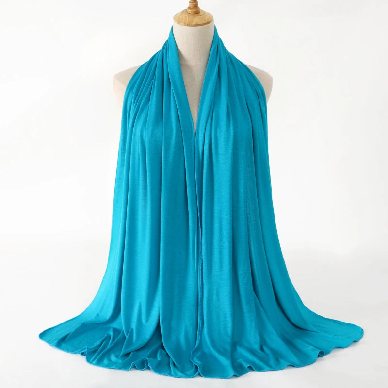 A vibrant turquoise premium modal jersey hijab draped around a mannequin's neck.