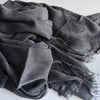 Foulard hijab en viscose coton gris foncé avec pompons drapé dans le tissu.