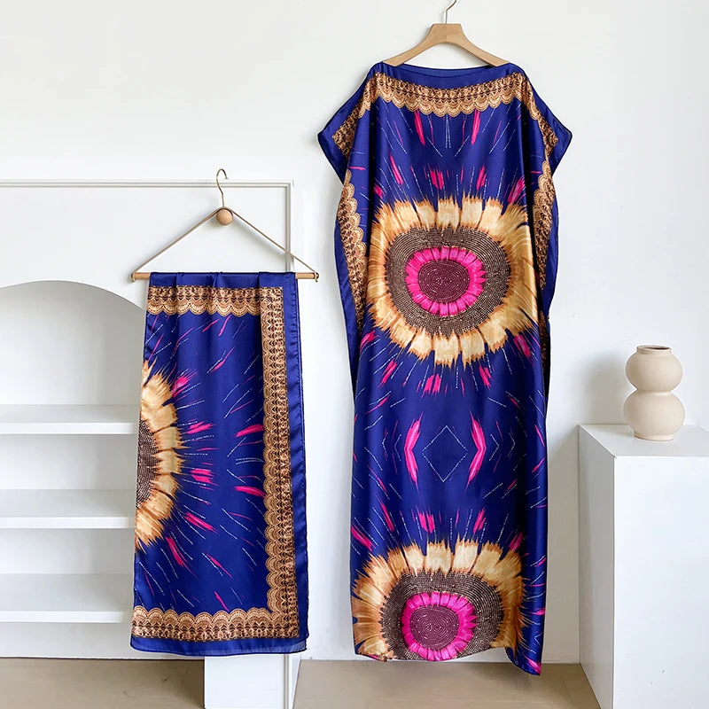 Kaftonkleid in königsblau mit leuchtendem Sonnenstrahlmuster in Gold- und Rosatönen.