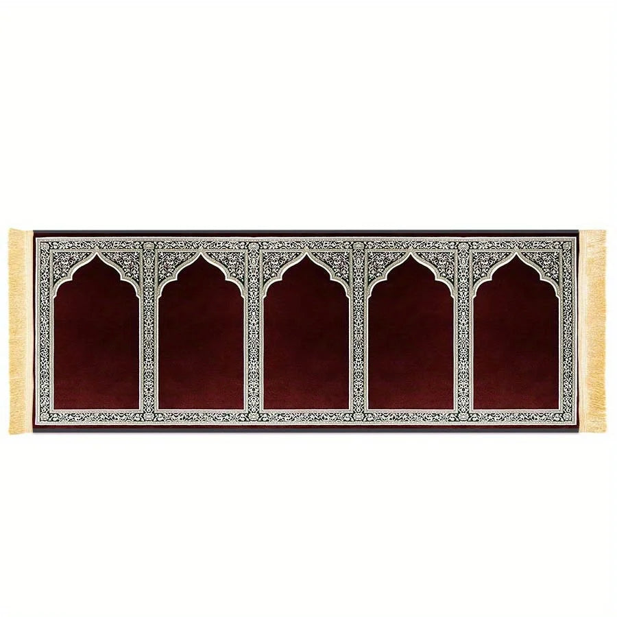 Un tapis de prière rectangulaire avec un fond de velours rouge foncé, des motifs architecturaux islamiques décoratifs et une 