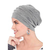 Eine Frau trägt eine graue Stretch-Baumwoll-Beanie-Turbanmütze mit einem silbernen Ohrring.