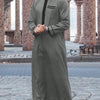 A man wearing a charcoal gray Moroccan ethnic thobe with a stand collar and black trim, standing outdoors.