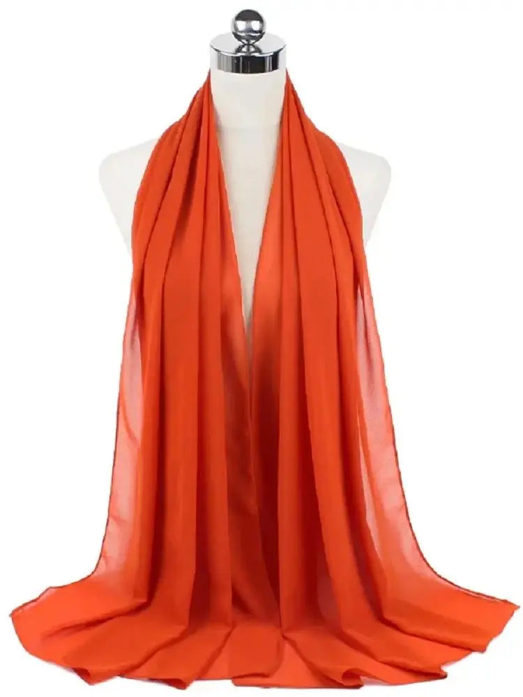 Orangerfarbiger, durcherzogener Chiffon-Hijabschal auf einem Mannequin-Hals.