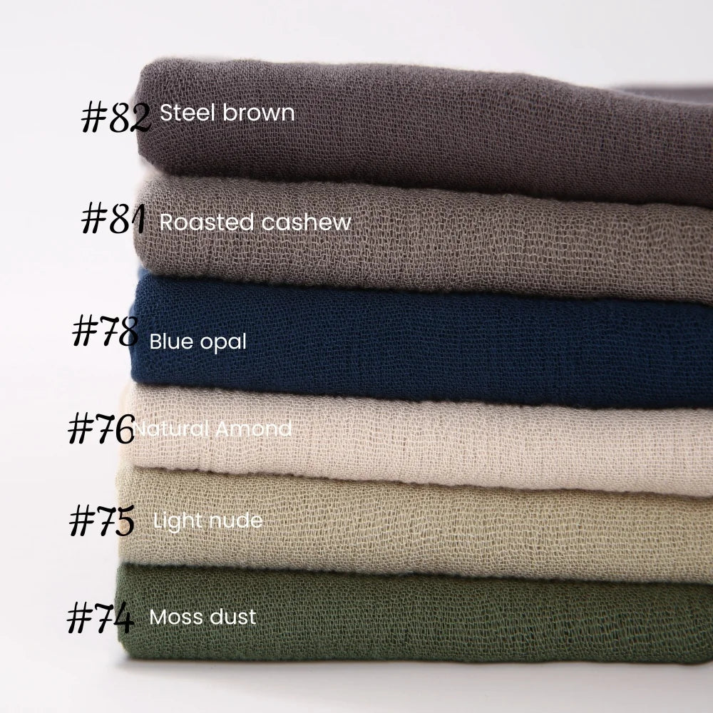 Pile de foulards de hijab en coton viscose de différentes couleurs avec pompons, numéros 74 à 82.