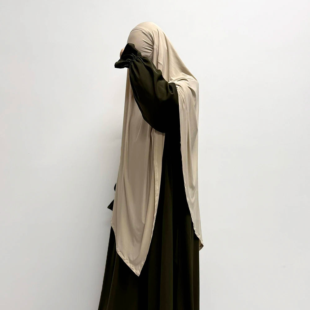 Eine Frau trägt einen beige-atmungsaktiven Bambus-Jersey-Khimar-Hijab in olivgrüner Farbe.