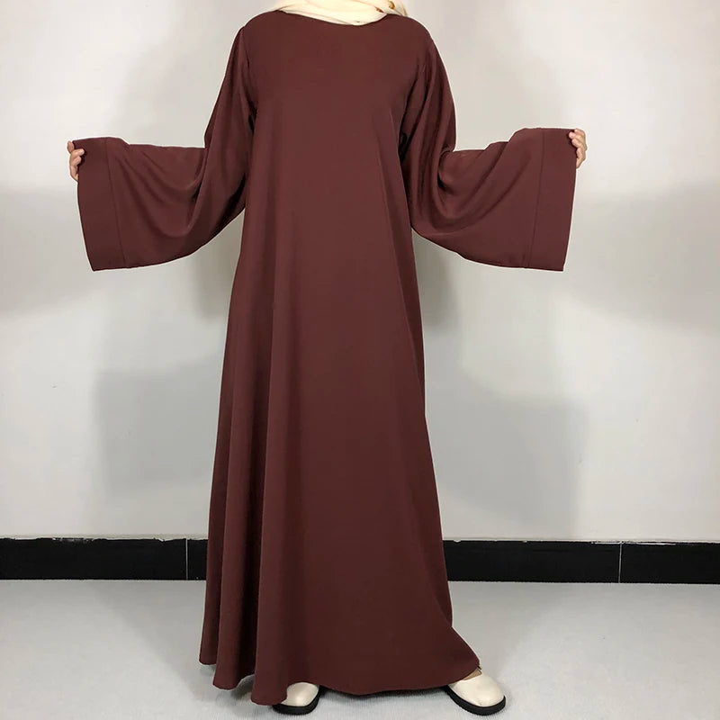 Une abaya marron foncé simple portée par un mannequin, avec une ceinture gratuite.