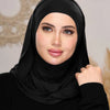 Eine Frau trägt einen schwarzen Instant Ready-to-Wear Jersey-Hijab-Schal und blickt direkt in die Kamera.