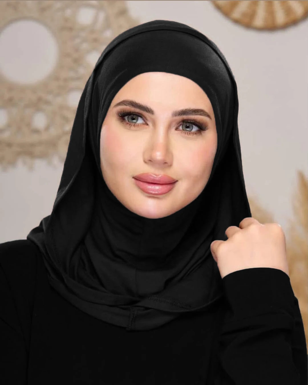 Eine Frau trägt einen schwarzen Instant Ready-to-Wear Jersey-Hijab-Schal und blickt direkt in die Kamera.