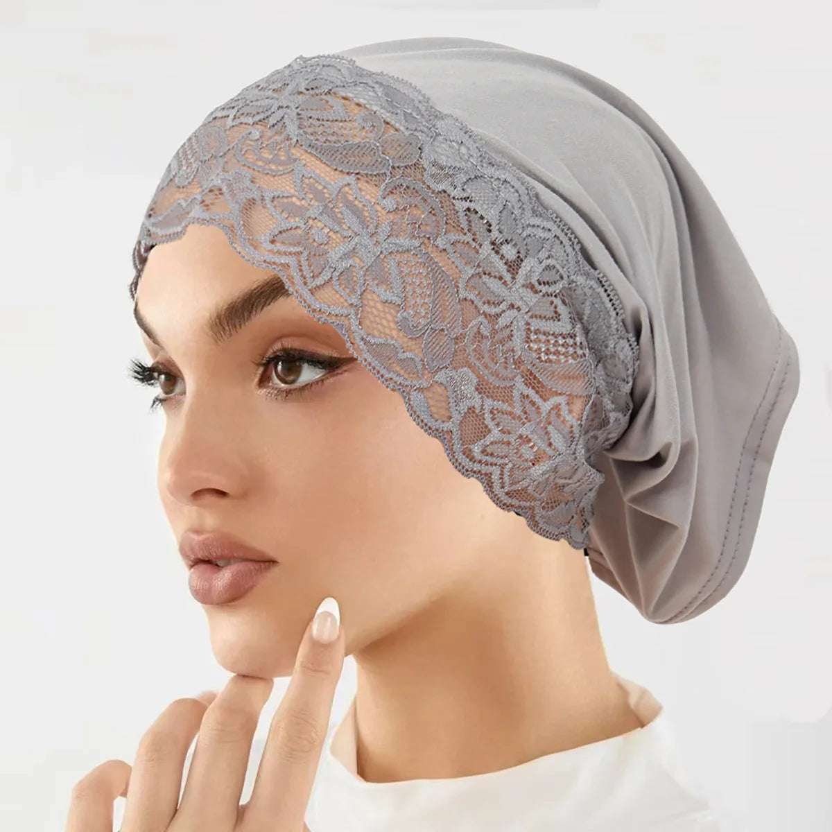 Model trägt ein graues Spitzen-Strick-Unterheidi-Turban-Bonnet.