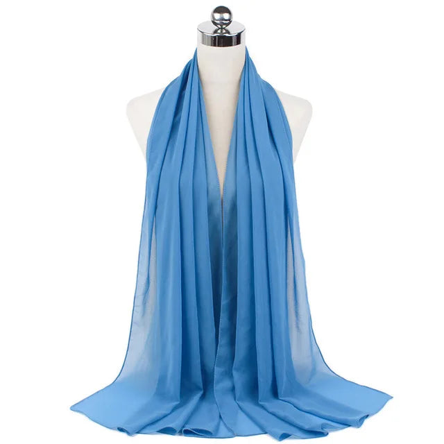 A light blue chiffon hijab scarf draped around a mannequin's neck.