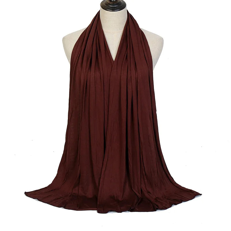 Un pañuelo de algodón modal color granate profundo premium drapeado alrededor del cuello de un maniquí.