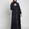 Eine Frau trägt eine schwarze marokkanische Kaftan-Abaya mit passender Hijab.