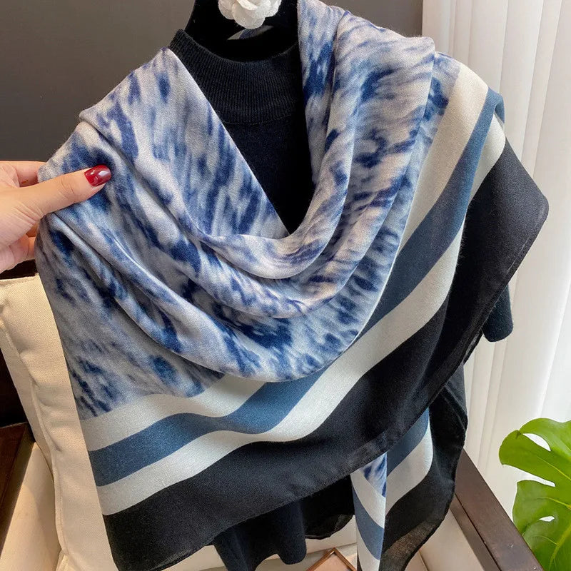 Blau-weißes Tie-Dye-Viskose-Schal über einem schwarzen Oberteil auf einem Mannequin.
