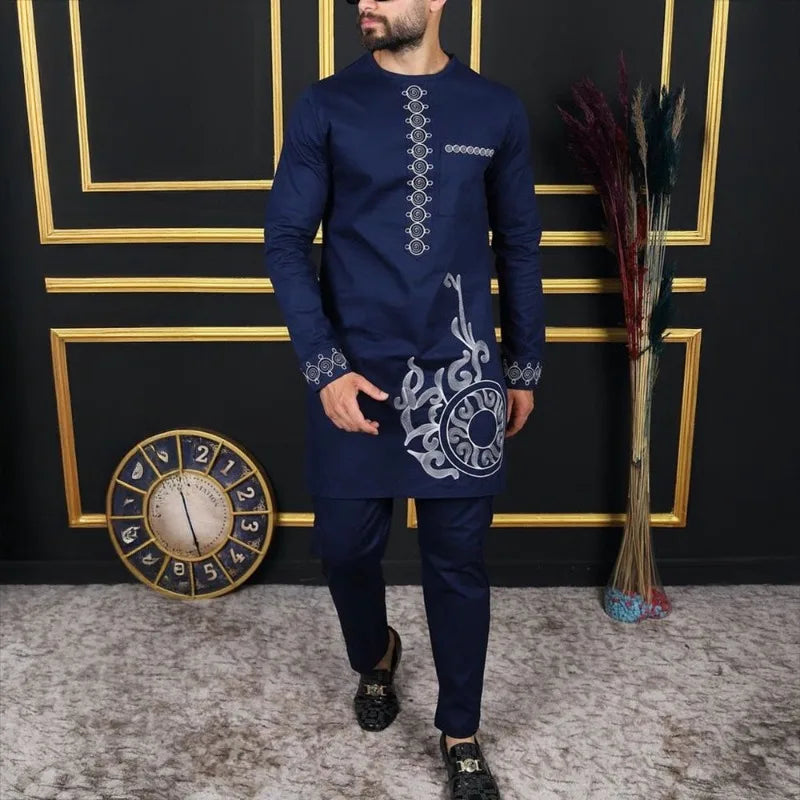 Un homme portant un costume de mariage musulman traditionnel africain bleu marine avec des accents dorés, devant un cadre dor