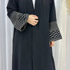 Une élégante abaya musulmane brodée bleu marine foncé portée par un mannequin.