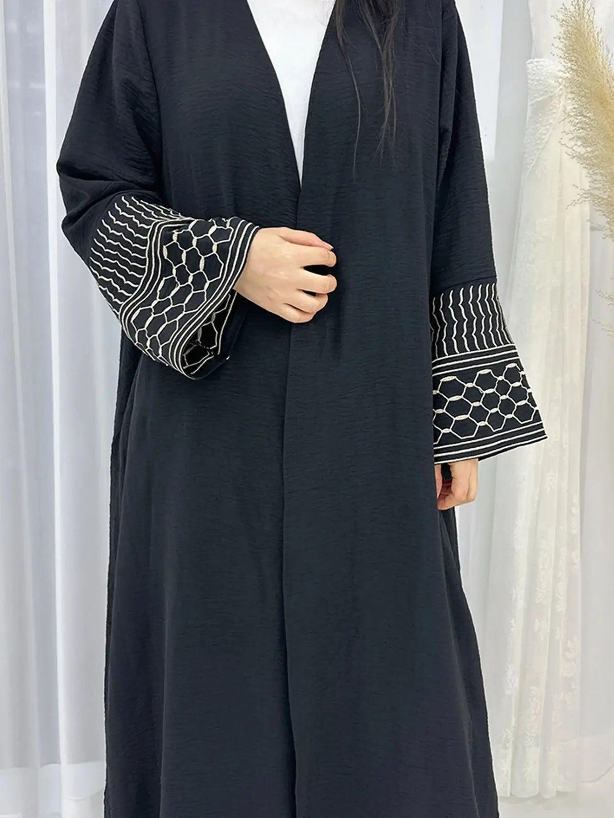 Une élégante abaya musulmane brodée bleu marine foncé portée par un mannequin.
