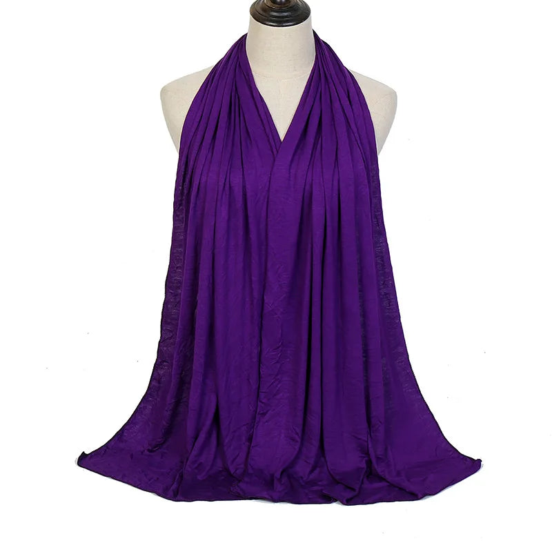 Pañuelo de algodón premium morado vibrante drapeado alrededor del cuello de un maniquí.