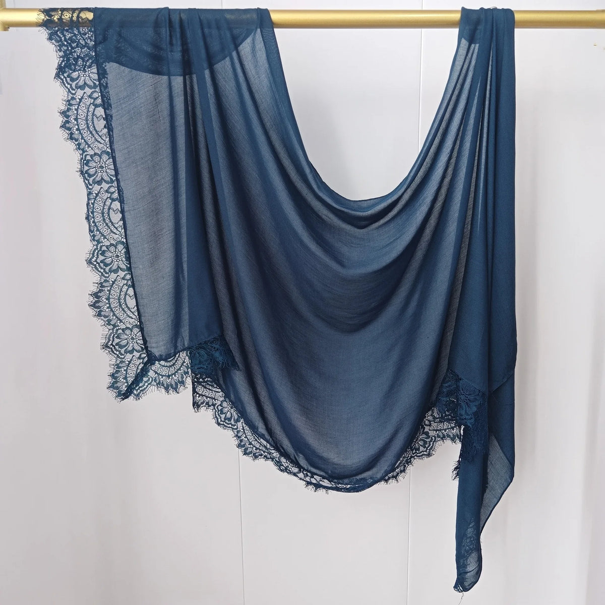 Hijab modal azul oscuro transparente con delicado ribete de encaje en los bordes.