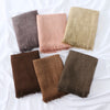 Collection de quatre foulards hijab en modal crinkle pliés dans des tons de brun, rose, beige et vert olive.