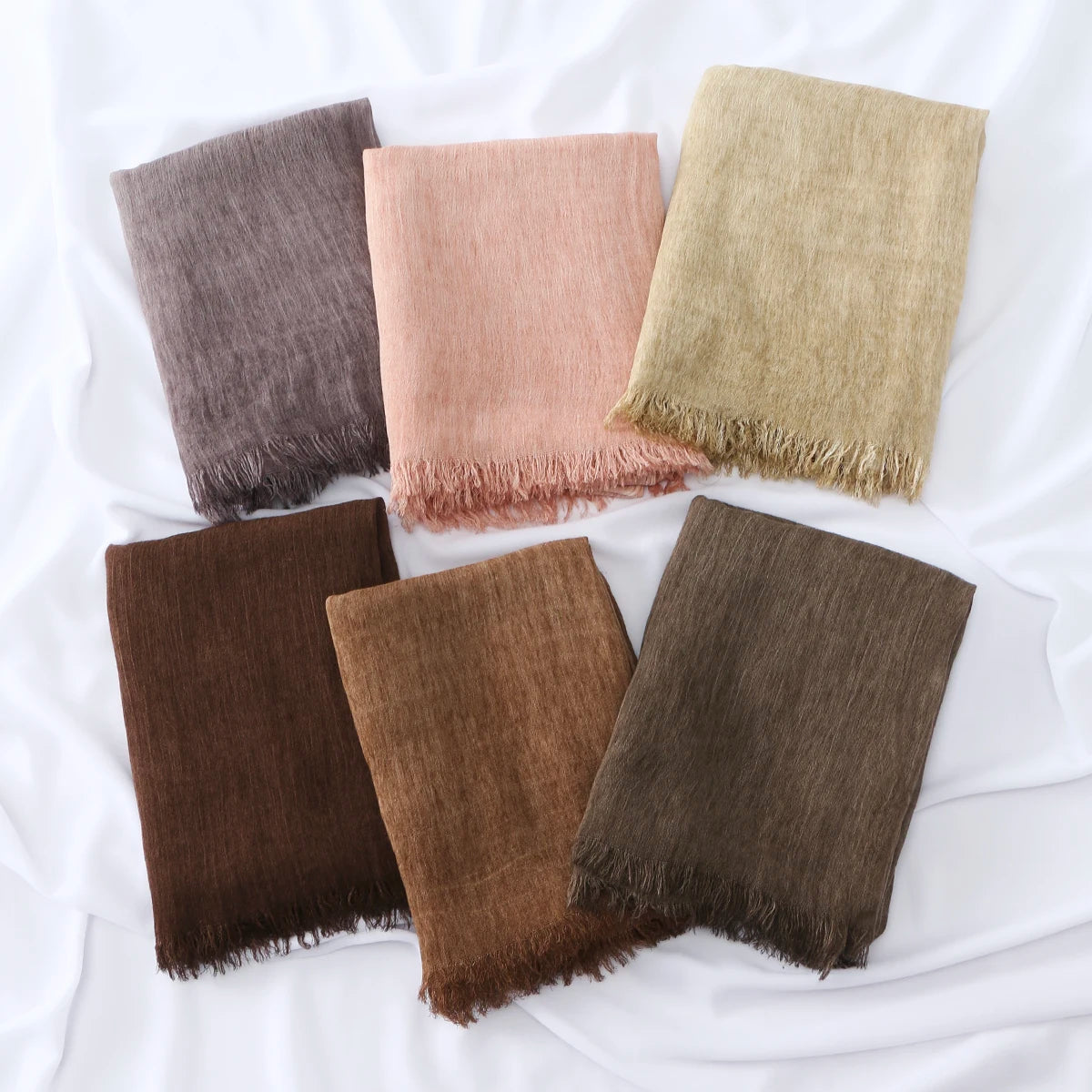 Collection de quatre foulards hijab en modal crinkle pliés dans des tons de brun, rose, beige et vert olive.
