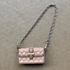 Bolso de cuero acolchado rosa claro con cierre dorado y correa de cadena plateada.