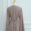Une abaya beige à cordon de serrage affichée sur un mannequin.