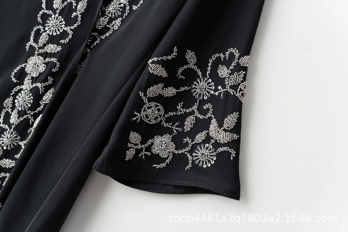 Black fabric with silver floral beaded embroidery on the sleeve of a luxury abaya set