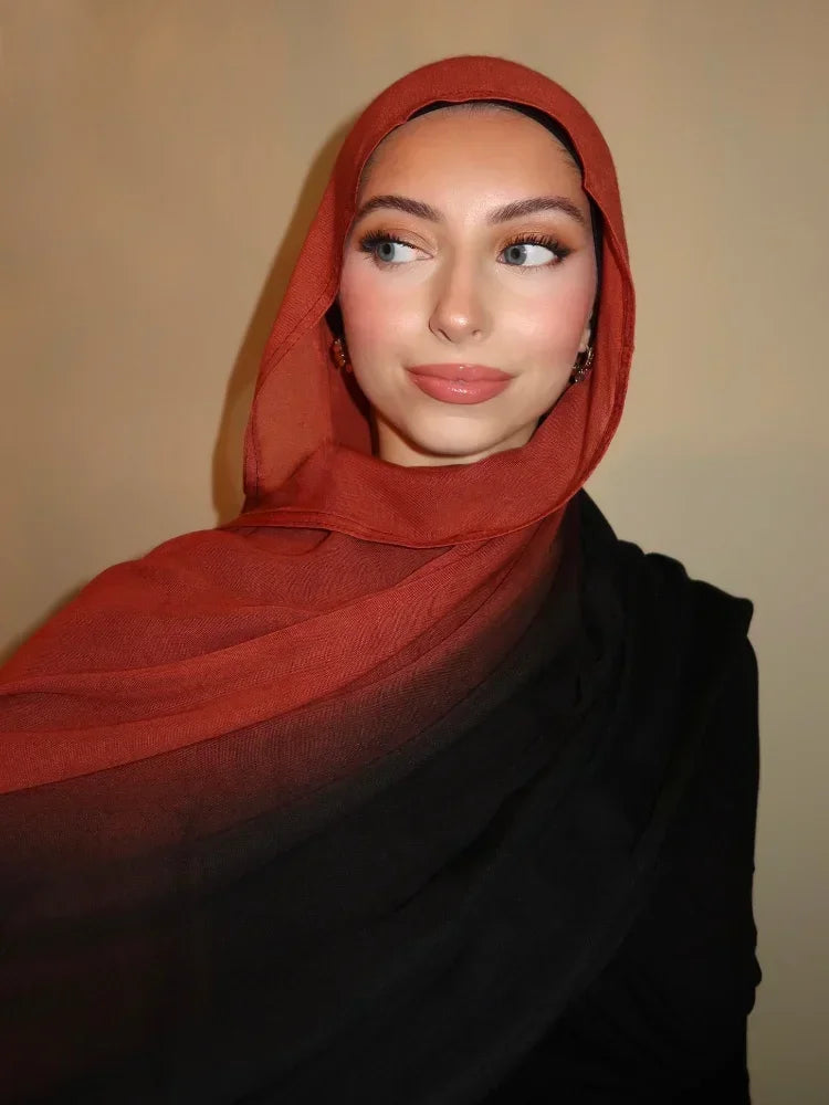 Eine Frau trägt einen gradienten orange-schwarzen Rayon-Modal-Hijab-Schal.