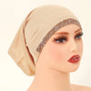 Cabeza de maniquí vistiendo un hiyab beige de algodón elástico modal con ribete dorado brillante.