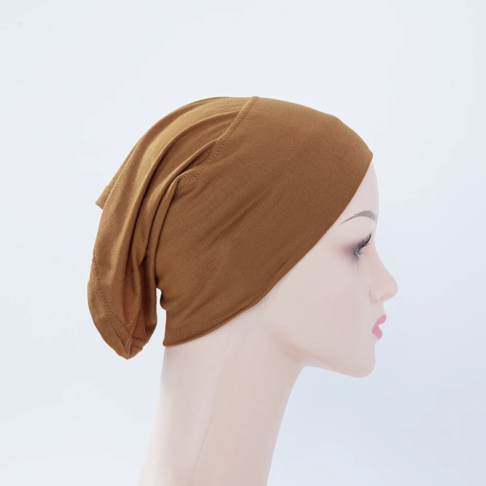 Nahaufnahme einer braunen Bambus-Jersey-Turban-Kappe auf einem Mannequin.