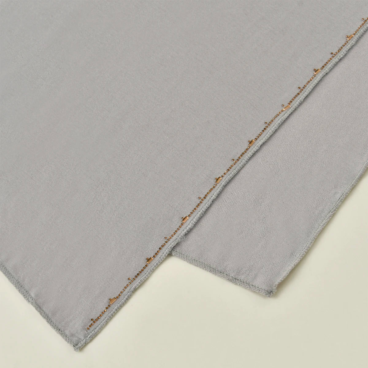 Pañuelo de gasa de algodón gris claro con borde brillante.