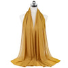 A flowing golden chiffon hijab scarf draped around a mannequin's neck.