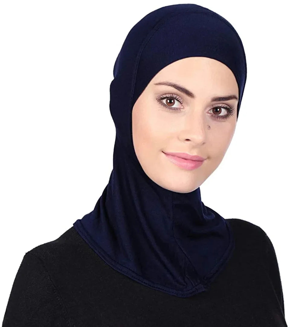 Une femme portant un hijab et un foulard bleu foncé sur un fond blanc.