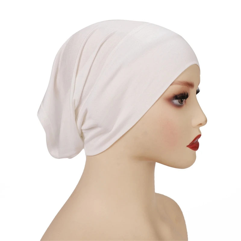 Una mujer usando un gorro hijab de modal de algodón suave y elástico rosa claro en un maniquí.