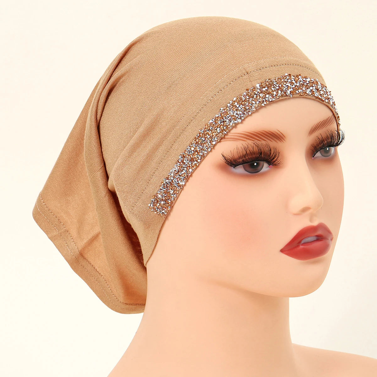 Modelo vistiendo unhiyab de algodón elástico beige con ribete dorado brillante en la frente.