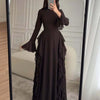 A full-length dark brown elegant high-waisted long-sleeve A-line maxi dress displayed in a mirror.