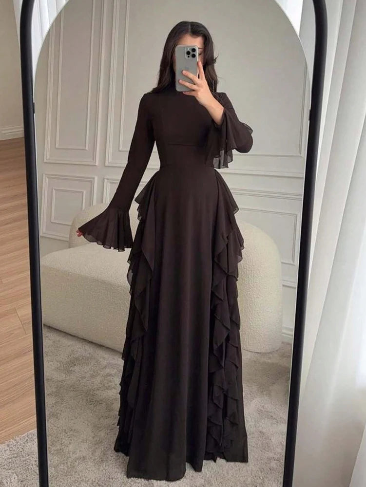 A full-length dark brown elegant high-waisted long-sleeve A-line maxi dress displayed in a mirror.
