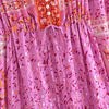 A close-up of a pink floral maxi dress featuring intricate embroidery and lantern sleeves.