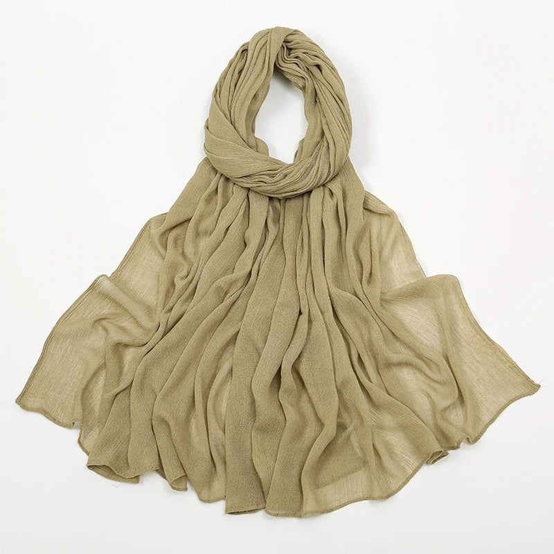 Étoffe beige à fronces drapée autour du cou et flottant sur les épaules.