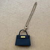 Bolso de cuero azul marino oscuro con cierre dorado y correa de cadena plateada.