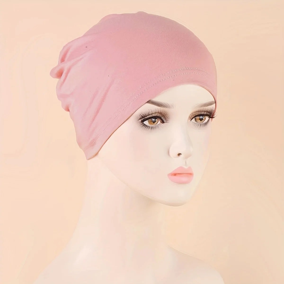 A pink classic stretch jersey turban cap displayed on a white mannequin head.