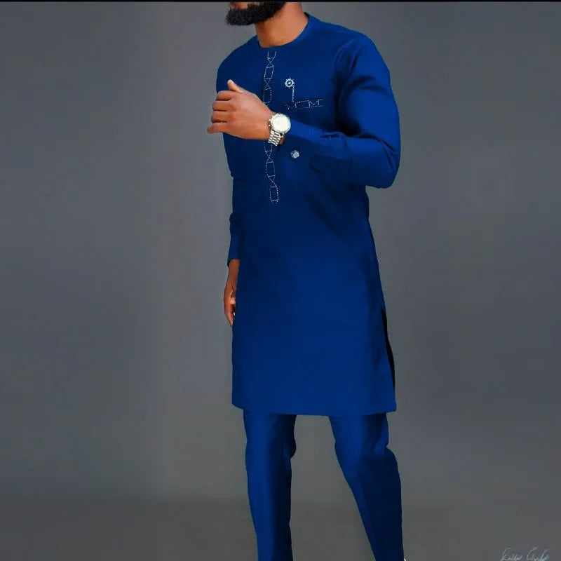 Un homme portant un costume de mariage musulman traditionnel africain bleu royal avec broderies dorées et pantalon assorti.