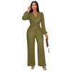 A woman models an olive green ribbed knit jumpsuit with a deep V-neck and puff sleeves.