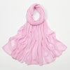 Écharpe en rayon rose doux et froissé drapée autour du cou et flottant sur les épaules.
